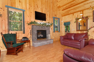 Living room with wood floors, wood walls, and wood ceilings featuring a leather couch